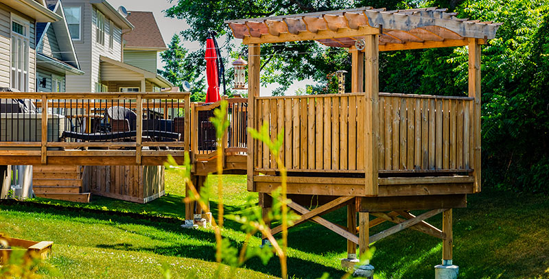 Deck with pergola in backyard of house.